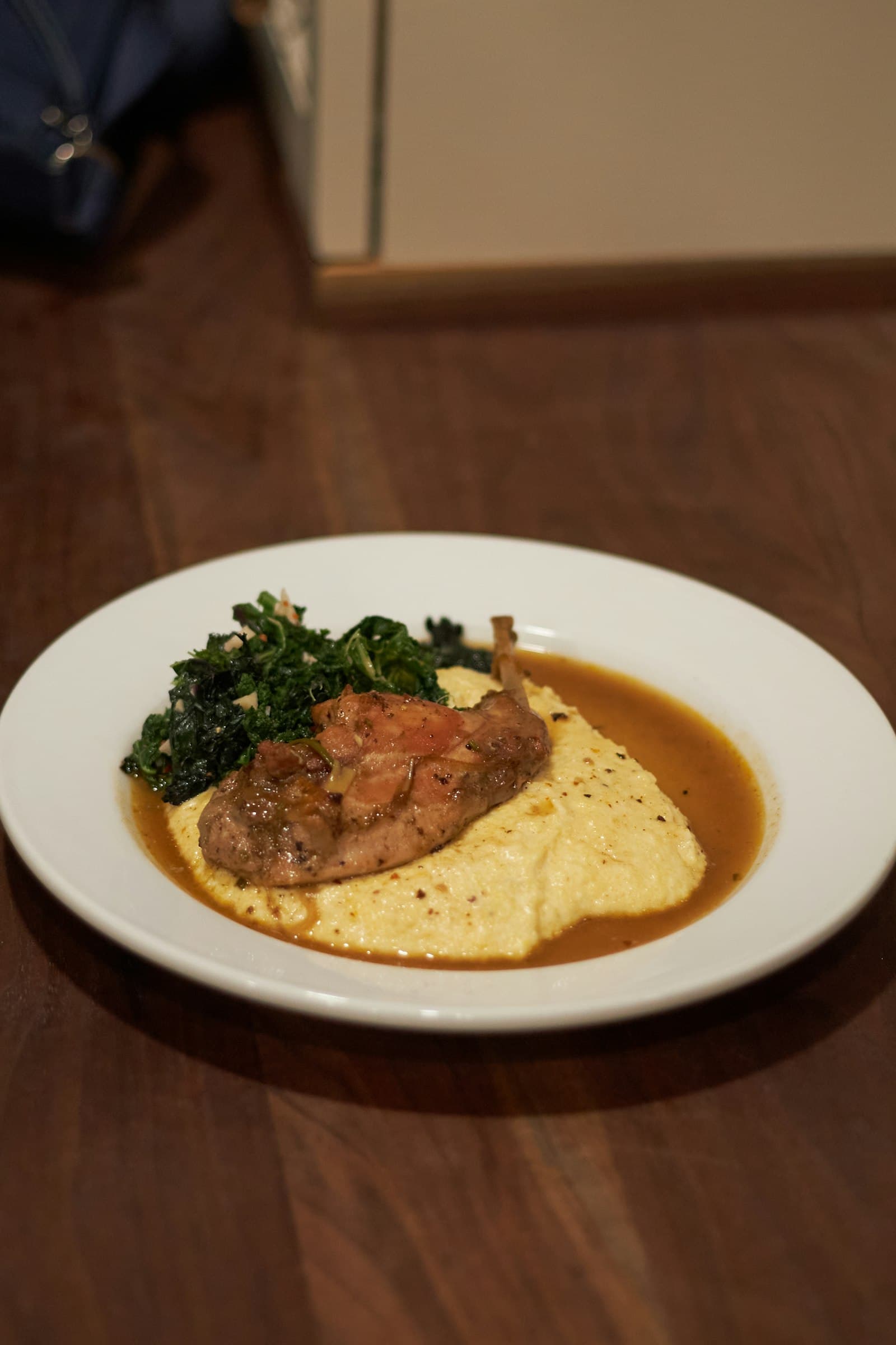 A plated portion of cooked rabbit with greens
